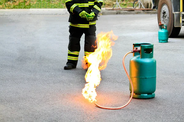 Fogo Queimando Recipiente Gás Verde Com Bombeiro Bombeiro Uniforme Preto — Fotografia de Stock