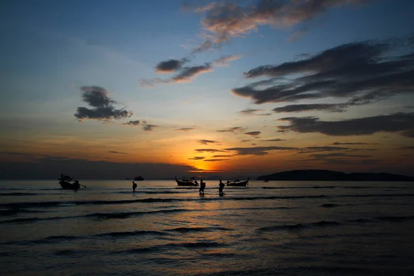 人々や観光客のシルエットは タイのクラビで海 青い空と雲の背景で旅行を取るためにロングテールボートを取得するために歩いています 夕暮れ時の自然の美しさ 海への旅 — ストック写真