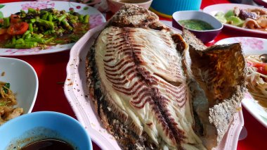 Tayland usulü ızgara tilapia 'yı pembe tabak ya da tabakla kapayın. Tayland' daki yerel sokak yemeklerinde diğer yemek geçmişleriyle birlikte. Taze balık ve sağlıklı yaşam tarzı..