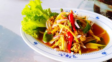 Tayland baharatlı at nalı yengeç yumurtası salatası ya da ekşi mango dilimi ve yeşil marul ile deniz ürünleri restoranında yengeç yumurtası. Asya ve diyet yemekleri