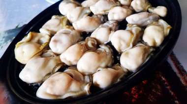 Taze istiridyeyi siyah tabak ya da tabağa koy. Deniz ürünleri ve deniz ürünleri..