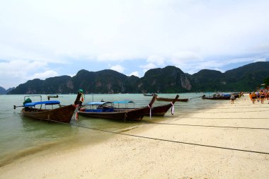 Tayland 'ın Krabi eyaletinde dağ ya da ada geçmişi olan turistleri almak için denize park etmiş bir sürü uzun kuyruk teknesi var. Tayland 'ın güneyinde şehir simgesi. Manzara deniz manzarası