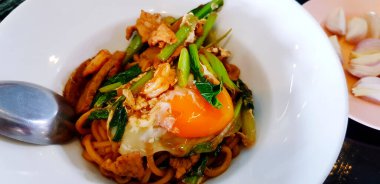 Beyaz tabakta ya da tabakta deniz ürünleri, lahana ve sarısı ile kurutulmuş Tayland eriştesi. Asya gıda kavramı