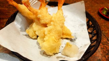 Tempura 'yı sarımsaklı smoothie ile Japon restoranındaki siyah sepetin üzerindeki beyaz yağ kağıdına kapatın. Japon usulü kızarmış karides ya da karides. Ana yemekten önce Asya yemeği ve atıştırmalığı..