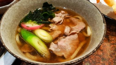 Udon şehriyesini çorba, dilimlenmiş domuz eti, yosun ya da alg ile kapatın Japon restoranında Japon bahar soğanı. Sıcak ya da Asya yemekleri. 