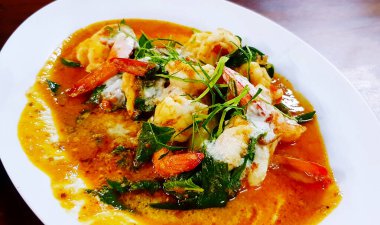 Kırmızı biber dilimlenmiş kırmızı körili karides, kaffir limon yaprağı, fesleğen ve bitkisel karışımı beyaz tabak ya da restoranda. Tayland Baharatlı Yemekler