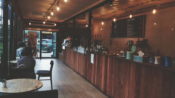 Bangkok, Tayland - 10 Temmuz 2020: Birçok insan kahverengi ahşap ve klasik tarzda hafif dekore edilmiş kafenin içinde yemek yiyip kahve içiyor. Tasarım ve Mimarlık konsepti