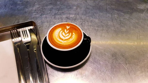 Café Capuchino Latte Art Taza Negra Con Servilleta Blanca Tenedor —  Fotos de Stock