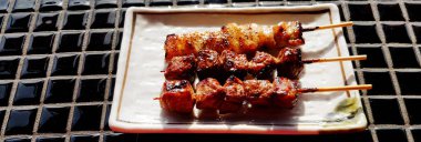 Japon wagyu bifteği beyaz tabakta ızgara ya da sokak yemekleri pazarında fayans masasında. Japonya 'da et barbeküsü ve ünlü yemekler