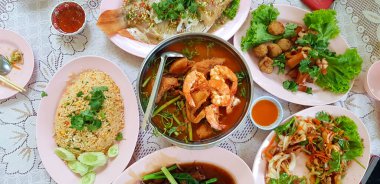 Tayland yemeği, kızarmış pilav, baharatlı salata, haşlanmış balık ve karides ve karışık sebzeli ekşi çorba. Baharatlı ve tatlı soslu Asya yemekleri manzarası.