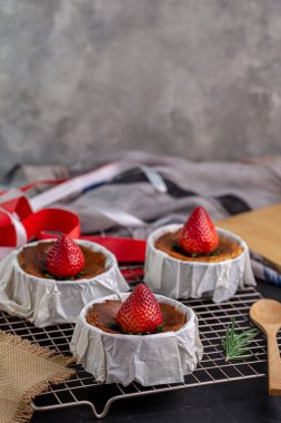 Yanmış peynirli kek, Parşömen kağıdına çilek soslu Bask peynirli keki..