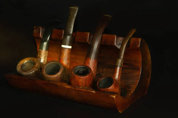 Natural wood tobacco pipes for smoking on a wooden display stand. Gifts for him or her.