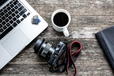 Dijital kamera ve bir fincan kahve ile dizüstü bilgisayar.