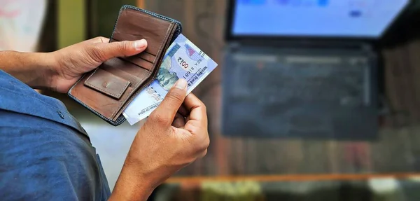 Genç adam cüzdan üst görünümünden kopya alan banknotlar ya da banknotlar alıyor.