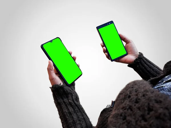 Perempuan Memegang Dua Ponsel Pintar Mengejek Tangan Dengan Layar Hijau — Stok Foto