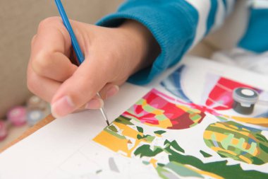 6 - çok renkli resimlere rakamlarla yakın çekim. Genç ve parlak kadın eli, parlak mavi boya fırçasını yeşile boyarken detaylarıyla tutuyor.