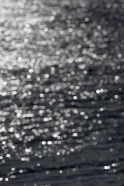 5 - Güneşli su dalgalanmalarının çözülmüş dikey görüntüsü, rastgele beyaz bokeh dairelerin soyut dokulu düz arkaplanı oluşturur. Su teması.