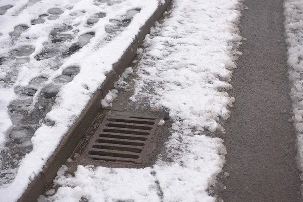 Winterliche Straßenszene Mit Oberflächlichem Sturmabfluss Der Das Abfließende Schwerwasser Aufnimmt lizenzfreie Stockfotos