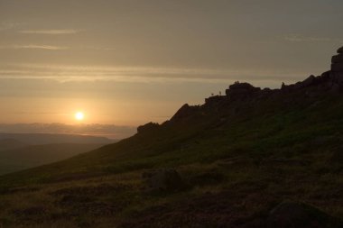 Tırmanışçılar, çiftler ve turistler gün batımında sıra sıra sıra diziliyorlar. Birçok insan açık havayı seviyor, geniş açı perspektifi.