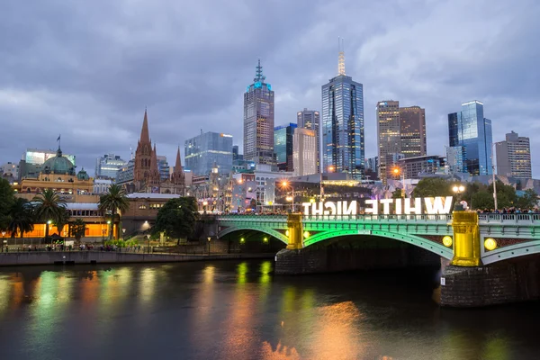 Melbourne, Ausztrália - február 22 2014: A Melbourne-i skyline, Flinders Street pályaudvartól és a Princes-híd alatt a fehér éjszaka fesztivál kivilágított — Stock Fotó