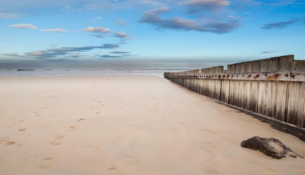 Holzzaun am leeren Strand bei Sonnenuntergang — Stockfoto