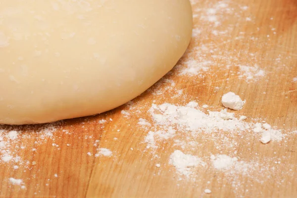 Freshly made pizza dough on a wooden chopping board — Stock Photo, Image