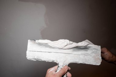 Alçıyı malanın üzerinde karıştırıyorum. Bıçak boyası. Duvarı boyayan araçlar