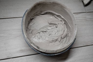 Evdeki duvarı yeniden inşa etmek için kovadaki macunlu çimento ürünleri sergilemek ya da montajlamak için kullanılabilir. sıva duvarları için harç dokusu - onarım, inşaat, iç dekorasyon.