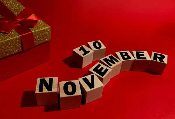 11月10日在木制立方体上 红色礼品盒在红色背景上 — 图库照片