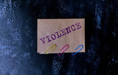 El işi kağıdındaki şiddet kelimesi siyah dokulu bir arka planda..
