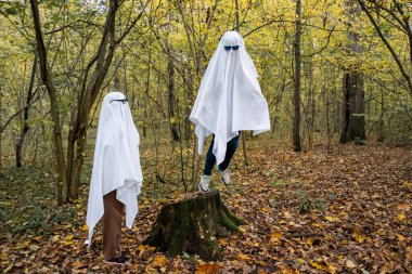 Ormanda ya da parkta hayalet yarışması. Beyaz çarşaflı ve güneş gözlüklü hayalet kılığına girmiş iki tanınmayan genç. Biri kütükten uçar, diğeri aşağıya bakar..