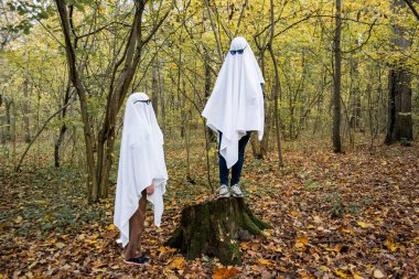 Ormanda ya da parkta hayalet yarışması. Beyaz çarşaflı ve güneş gözlüklü hayalet kılığında tanınmayan iki genç. Biri kütüğün üzerinde duruyor, diğeri aşağıya bakıyor..