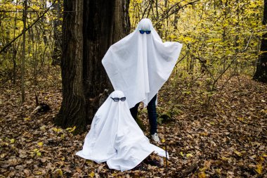 Ormanda ya da parkta hayalet yarışması. Beyaz çarşaflı ve güneş gözlüklü hayalet kılığına girmiş iki tanınmayan genç. Biri diğerinin üzerinde duruyor, eski bir ağaç arka planı..