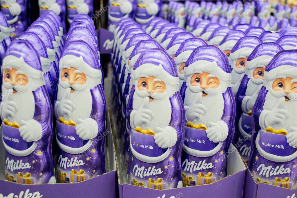 Moscow, Russia, November 2020: Close up of lots of chocolate winking Santa Claus Milka in purple.