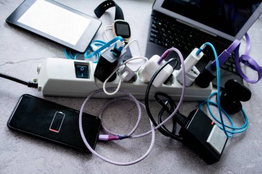 Moskova, Rusya, Ağustos 2020: Birçok cihaz: Akıllı telefon, kablosuz kulaklık, dizüstü bilgisayar, akıllı saat, kamera aküsü ve e-kitap bir elektrik hattında şarj ediliyor.