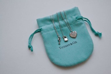 Moskova, Rusya, Kasım 2019 Tiffany and Co. Markalı paketleme mücevheri: yumuşak turkuaz çanta üzerinde gümüş anahtar, kilit ve kalp var. Beyaz arka plan. Boşluğu kopyala.