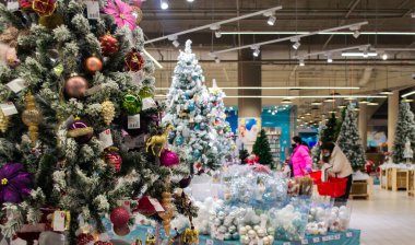 Moskova, Rusya, Kasım 2020: Maskeli müşteriler alışveriş merkezindeki bir Noel satışında Noel oyuncaklarını görüyor ve seçiyorlar.