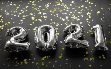 Siyah arka planda parlak altın ve gümüş yıldızlı şişirilebilir sayılar 2021. Boşluğu kopyala.