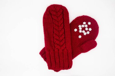 Beyaz arka planda beyaz kar taneleri olan kırmızı eldivenler, izole edilmiş. Noel, kış, aşk kavramı. Bakım ve Sevgililer Günü. Boşluğu kopyala.