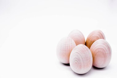 Beyaz arka planda beş el yapımı boyanmamış ahşap yumurta.