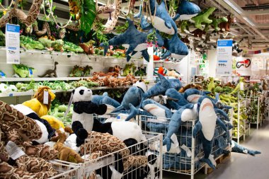 Moskova, Rusya, Şubat 2021: Bir Ikea mağazasındaki raflarda bir grup yumuşak oyuncak: köpekbalıkları, dinozorlar, pandalar ve yılanlar. Oyuncaklar raflarda, tavanda ve sepetlerde.