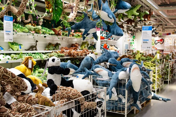 Moskova, Rusya, Şubat 2021: Bir Ikea mağazasındaki raflarda bir grup yumuşak oyuncak: köpekbalıkları, dinozorlar, pandalar ve yılanlar. Oyuncaklar raflarda, tavanda ve sepetlerde.