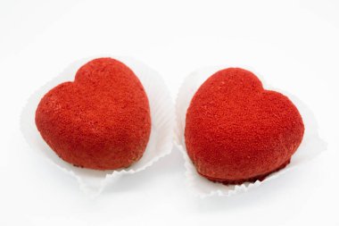 Beyaz arka planda parlak kırmızı kalp şeklinde kekler. Boşluğu kopyala.