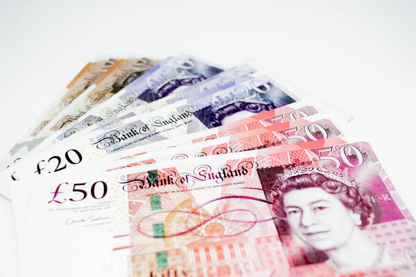 MOSCOW, Russia, February 2020: A pile of ten, twenty and fifty pounds on the right on a white background. Copy space.