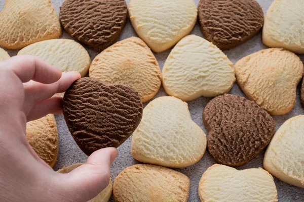 Hand Holds Heart Shaped Chocolate Cookie Backdrop Many Colorful Cookies — Stock Photo, Image