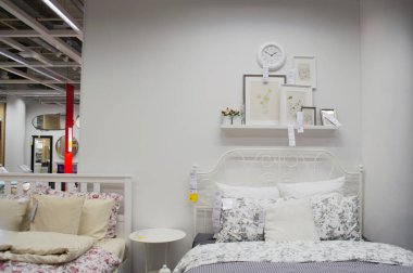Moskova, Rusya, Eylül 2019: IKEA 'nın yatak odası içi: beyaz renkli yatak, keten, fotoğraf çerçeveleri ve duvar saati. Mobilya mağazası.