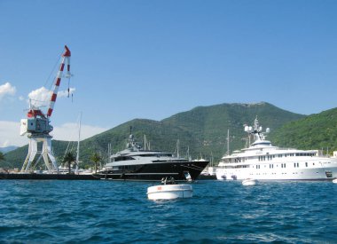 Karadağ, Haziran 2011: Karadağ kıyısı açıklarındaki özel yatların demirleme yerindeki suya bakın. Park yerinde siyah, beyaz yatlar, limanda bir vinç ve denizde büyük bir şamandıra var..