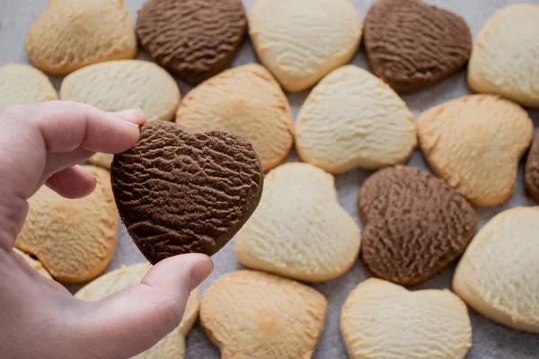 Hand Holds Heart Shaped Chocolate Cookie Backdrop Many Colorful Cookies — Stock Photo, Image