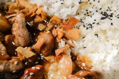 Vietnam yemeklerinin yakın çekimi: siyah susam tohumları serpiştirilmiş pirinç, et sosu, kızarmış havuç..