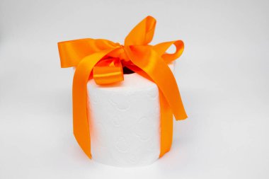 Beyaz tuvalet kağıdı rulosu. Parlak turuncu saten kurdeleyle bağlanmış..